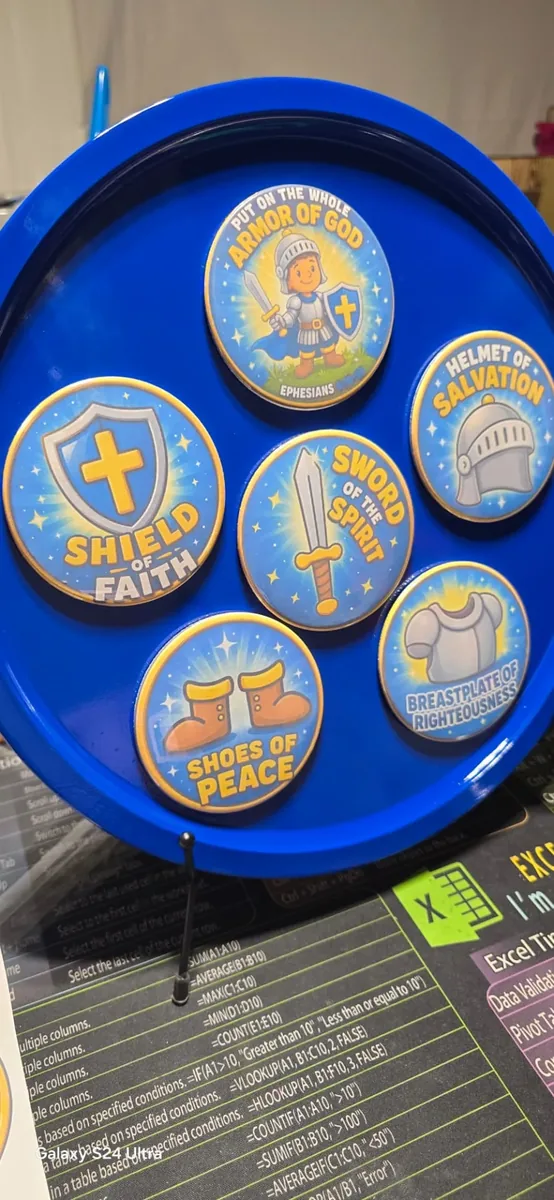 Armor of God button set on a blue display tray with Shield of Faith, Sword of the Spirit, Helmet of Salvation, Breastplate of Righteousness, and Shoes of Peace